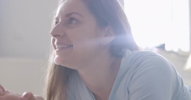 Close-up side view of happy Caucasian woman sitting in sunrays and asking her baby to come up. Mother enjoying sunny day with child. Happiness, joy of motherhood. Cinema 4k ProRes HQ. — Stock Video