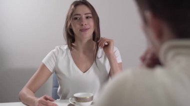 Ön planda tanınmayan bir bayanla duygusal olarak konuşan beyaz bir kadının yüzü. Esmer kız annesine hayatındaki haberleri anlatıyor. Kadınlar evde dinleniyor ve sıcak çay içiyor..