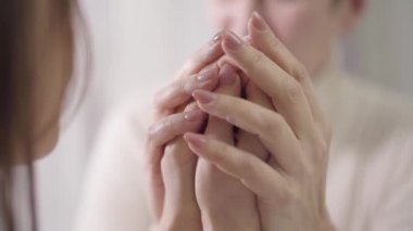 Konuşan ve el ele tutuşan iki bulanık kadın. Anne ve kız, özen, birlik.