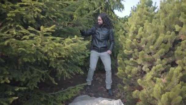 Positieve hippie man die opduikt uit bomen en jonge mooie blonde vrouw leidt. Gelukkig jong multiraciaal koppel daterend uit het herfstbos. Vrolijke mensen die buiten rusten. — Stockvideo