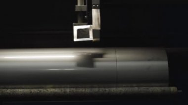 Metal borudaki kıvrımları kesen makinenin yakın çekimi. Ekipmanlar üretim sahasında çalışıyor. Çelik endüstrisi, çelik üretimi, sanayi, imalat.