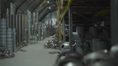 Metal üretim deposu. Nakliye terminalinde metal borular ve metal eşyalar var. Çelik endüstrisi, metal üretimi, imalat. Kamera sağdan sola hareket ediyor.