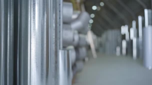 Ready production warehouse, freight terminal of steel products. Steel industry, metal production, manufacturing. Camera moving from right to left, shooting behind metal pipe. — Stock Video