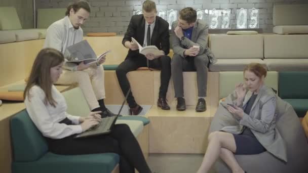 Kaukasische kantoormedewerkers werken in creatieve open ruimte. Vijf jonge mannen en vrouwen die aan hun project denken. Moderne levensstijl, coworking, kantoor, bedrijf, creativiteit. — Stockvideo