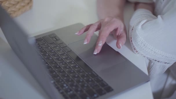 Close-up de mãos femininas caucasianas usando tachpad e digitando no laptop. Senior mulher inteligente com francês manicure surf internet. Passatempo, passatempo, lazer . — Vídeo de Stock