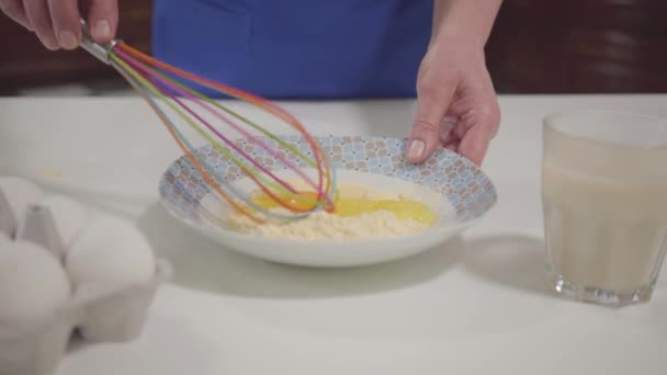 Primer plano de las manos caucásicas femeninas mezclando harina con huevos. Madre o abuela horneando en casa. Hobby, actividad de ocio . — Vídeo de stock