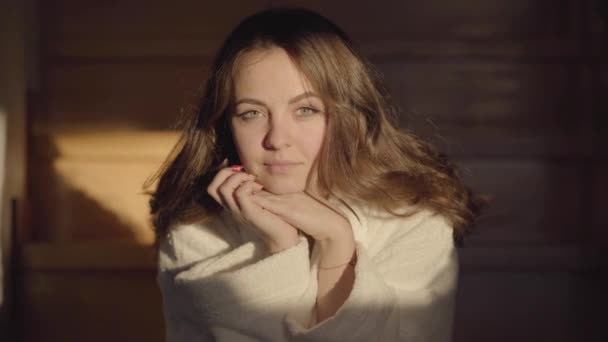 Close-up face of gorgeous Caucasian woman looking at camera and smiling. Portrait of young brunette girl with hazel eyes in sunrays. Beauty, natural, real people. — Stock Video