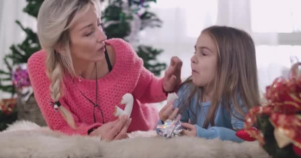 Jeune mère caucasienne essuyant les filles visage sale avec des bonbons. Mère blonde prenant soin de sa fille. Les gens se reposent la veille de Noël à la maison. Siège social Cinema 4k ProRes . — Video