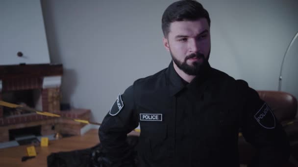 Πορτρέτο του όμορφου Καυκάσιου γενειοφόρου αστυνομικού που στέκεται στον τόπο του εγκλήματος και σκέφτεται. Νεαρός ντετέκτιβ που σκέφτεται για φόνο. Επαγγελματική, έρευνα. — Αρχείο Βίντεο