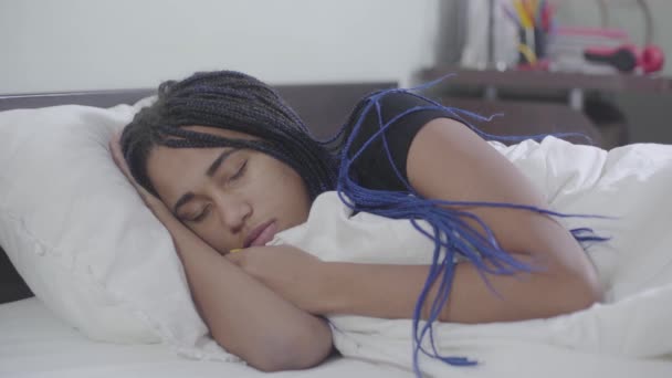 Portret van een rustige Afro-Amerikaanse vrouw met dreadlocks die slaapt. Jong schattig meisje dat thuis rust. Vrije tijd, weekends, levensstijl. — Stockvideo