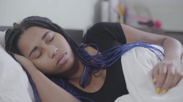 Faccia da primo piano della ragazza afroamericana che dorme e ripara la coperta bianca. Adolescente con i dreadlocks che riposano a casa. Fine settimana, ora di andare a letto, tempo libero . — Video Stock