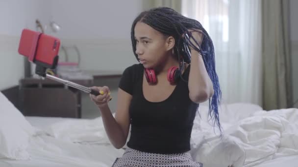 Cute African American girl holding selfie stick with smartphone and talking. Teenager communicating with friends online. Modern lifestyle, wireless technologies, social media. — Stock Video