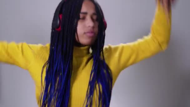 Portrait of positive African American girl dancing in headphones. Cheerful teenager having fun. Lifestyle, happiness, listening to music, hobby. — Stock Video