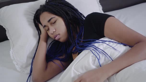 Visão superior da menina afro-americana com dreadlocks dormindo e fixando cobertor. Jovem adolescente bonito descansando na cama branca. Lazer, fins de semana, estilo de vida . — Vídeo de Stock