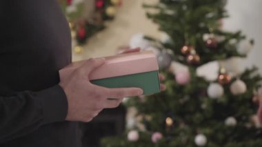 Kamera, beyaz bir erkek tarafından tanınmayan genç bir kıza verilen hediye kutusunu takip ediyor. Yeni yıl arifesinde Noel hediyesi alan gülümseyen kadın. Tatil, kutlama, mutluluk..