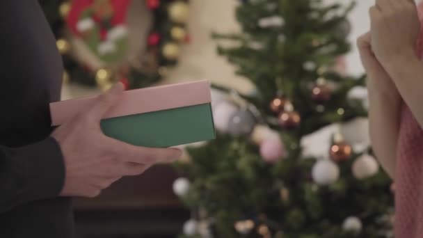 Gros plan de femmes blanches prenant boîte cadeau devant l'arbre de Noël, l'ouvrant et jetant en arrière. Fille mécontente des conjoints du Nouvel An présent. Problèmes relationnels, colère . — Video