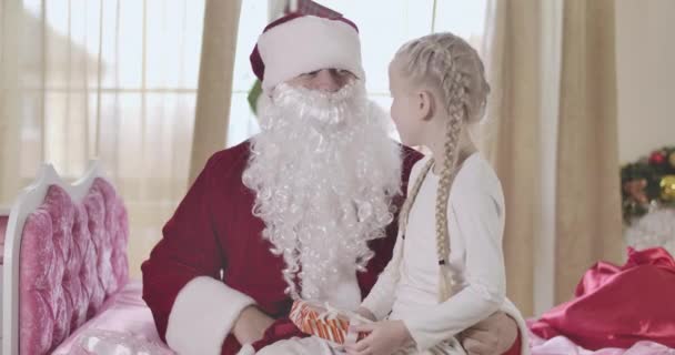 Neşeli beyaz sarışın kız babasının takma sakalını çıkarıyor. Noel Baba kostümlü pozitif sakallı adamın sırrını ortaya çıkaran kızı. Noel mucizesi. Sinema 4k Prores Merkezi. — Stok video
