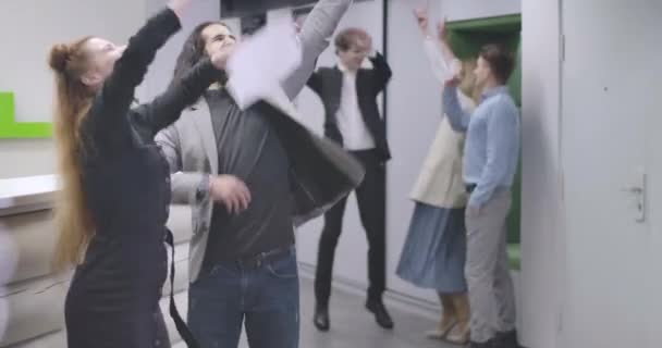 Retrato de un grupo de jóvenes trabajadores de oficina arrojando papeles y saltando. Equipo multiétnico que celebra el éxito empresarial. Sede del cine 4k ProRes . — Vídeo de stock