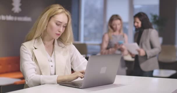 Retrato de una joven mujer caucásica grave escribiendo en el teclado del ordenador portátil. Retrato del exitoso CEO de confianza en el lugar de trabajo. Mujer de negocios, gerente, eficiencia, oficina, estilo de vida. Sede del cine 4k ProRes . — Vídeos de Stock