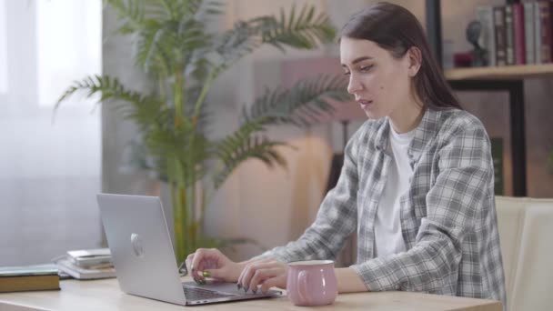 Menina morena caucasiana feliz olhando para a tela do laptop, balançando a cabeça e fechando o dispositivo. Jovem freelancer do sexo feminino tendo conversação de vídeo online. Freelance, trabalho distante, empresária . — Vídeo de Stock