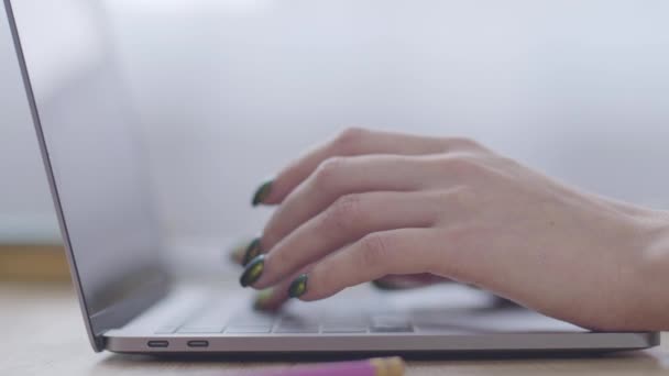 Gros plan des mains féminines caucasiennes tapant rapidement sur le clavier de l'ordinateur portable. Travail de bureau, technologies modernes, communication en ligne .