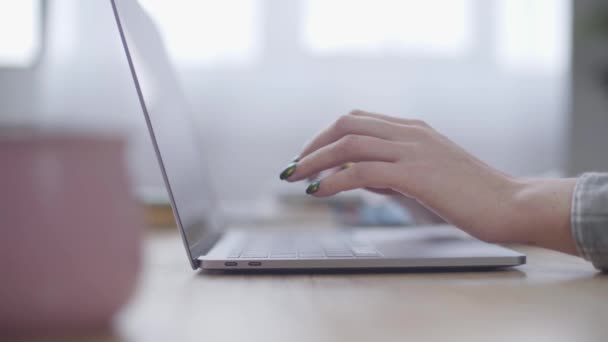 Laptop stojący przy stole, kobiece, kaukaskie ręce piszące szybko na klawiaturze. Praca biurowa, nowoczesne technologie, komunikacja online. — Wideo stockowe