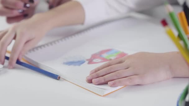 Close-up af kaukasiske børn hænder tegning med farverig blyant i øvelsesbog. Maleri, studier, uddannelse, kreativitet . – Stock-video
