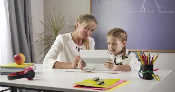 Retrato de mujer caucásica tutor privado enseñando lindo niño con coletas en casa. Mujer de mediana edad y colegiala aprendiendo matemáticas. Educación, estudio, diligencia. Sede del cine 4k ProRes . — Vídeo de stock