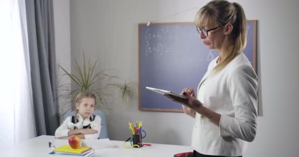 Colegiala positiva caucásica haciendo un gesto de victoria sentada a la mesa. Tutora mujer adulta enseñando en casa. Educación, felicidad, inteligencia. Sede del cine 4k ProRes . — Vídeos de Stock