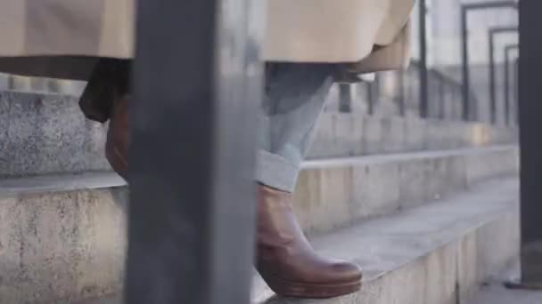 Close-up de pernas femininas caucasianas em jeans e botas marrons descendo as escadas. Estilo de vida, pressa, empresários . — Vídeo de Stock