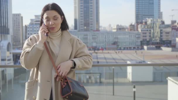 Portrait of successful Caucasian woman standing on city street and talking on the phone. Pretty brunette businesswoman working in the city. Lifestyle, overworking. — Stock Video