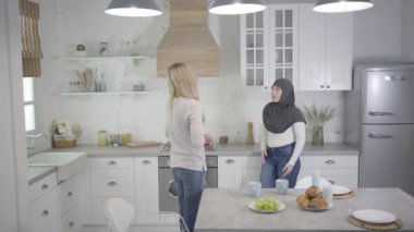 Başörtülü Müslüman kadın evde sarışın beyaz bir arkadaşla tartışıyor. İçeride kavga eden iki kadın. Yanlış anlama, çok ırklı iletişim, ilişki sorunları.