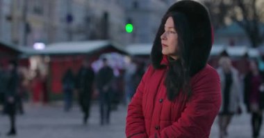 Orta yaşlı, üzgün, beyaz bir kadın caddede dikilip etrafa bakıyor. Yetişkin çekici bayan şehir pazarında birini bekliyor. Yaşam tarzı, boş zaman, toplantılar. Sinema 4k Prores Merkezi.