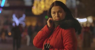 Donmuş Kafkas kadın şehir caddesinde duruyor ve bekliyor. Açık hava pazarında kendine güvenen yetişkin bir bayan dinleniyor. Yaşam tarzı, boş zaman, hafta sonları. Sinema 4k Prores Merkezi.