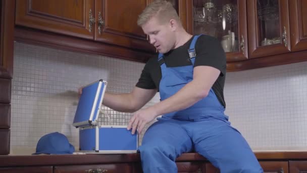 Portrait d'homme rousse caucasien joyeux assis à la cuisine, décoller tasse avec boisson chaude, et surfer sur Internet. Travailleur sans scrupules se reposant sur le lieu de travail. paresse, travail, services de réparation .