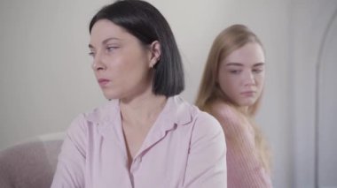 Sarışın, beyaz bir kızın portresi annesine dönüp omzuna dokunuyor. Çatışmadan sonra ergen kız annesiyle barışacak. Aile ilişkisi, çatışma, sorunlar.