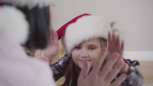 Gros plan portrait de jolie fille caucasienne jouant avec sœur aînée et mère. Heureux enfant passe du temps libre avec sa famille à la maison. Bonheur, loisirs, détente . — Video