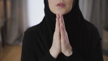 Kadın ellerinin birbirine yakın çekimleri. Tanımlanamayan genç Müslüman kadın evde dua ediyor. Din, yaşam tarzı, kültür.