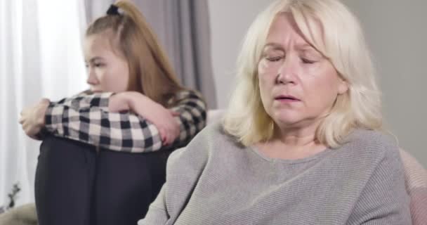 Portret van een mooie blonde blanke vrouw met grijze ogen die terugkijkt op haar kleindochter en haar hoofd schudt. Overstuur bezorgde oma in conflict met kleindochter. Bioscoop 4k Prores Hq. — Stockvideo