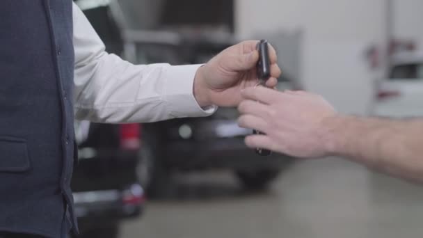 Close-up de mãos masculinas caucasianas de mecânico de automóveis levando chaves de carro de homem irreconhecível. Proprietário bem sucedido dando seu automóvel para reparar e apertar a mão dos trabalhadores. Garantia, serviço . — Vídeo de Stock