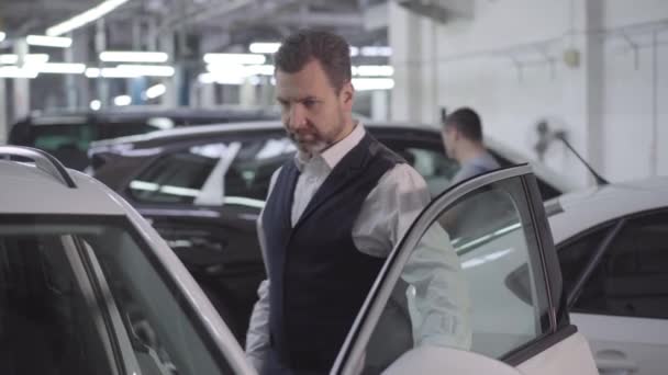 Portrét sebevědomého bělocha, který otevírá dveře auta a dotýká se automobilu. Bohatý muž kontroluje své vozidlo po opravě v obchodě. Záruka, servis. — Stock video