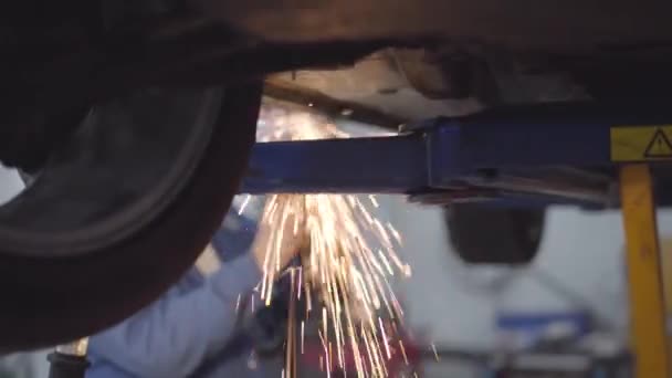 Male unrecognizable Caucasian auto mechanic welding car. Professional working in repair shop. Occupation, profession, lifestyle. — Stock Video