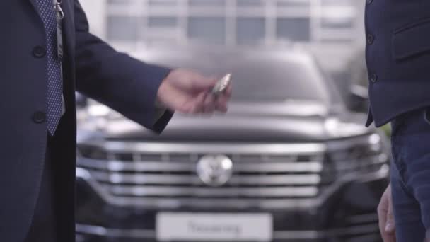 Närbild av manliga kaukasiska händer som ger bilnycklar till kunden och skakar hand. Bilhandlare återvänder fast bil till kunden efter garantireparation. Bilindustri, reparation. — Stockvideo