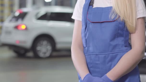 Unrecognizable female auto mechanic taking wrench. Young Caucasian woman in workrobe standing in repair shop. Profession, occupation. — 비디오