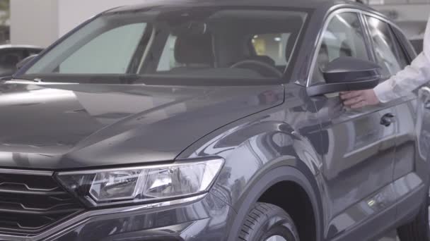 Adult Caucasian businessman opening car door and sitting at drivers seat. Handsome man in elegant clothes taking his car back after repair. Car business, warranty service. — Stock Video