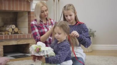 Kamera, güzel beyaz bir kızın ablası ve örgü ören annesi gibi oyuncak bebekle oynamasına yaklaşıyor. Mutlu arkadaş canlısı aile evde boş zaman geçiriyor. Birlik, rahatlık, yaşam tarzı.