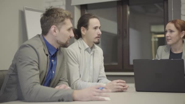 Positive Caucasian men and woman discussing business project at the meeting. Adult coworkers sharing business ideas in open space office. Communication, discussion, management. — Stock Video