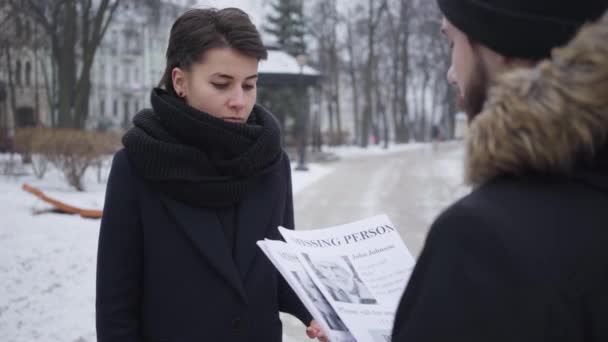 Portret van een empathische blanke vrouw die een advertentie van een bebaarde jongeman aanneemt. Zoon op zoek naar zijn oudere vader. Familie, ontvoering, verlies. — Stockvideo