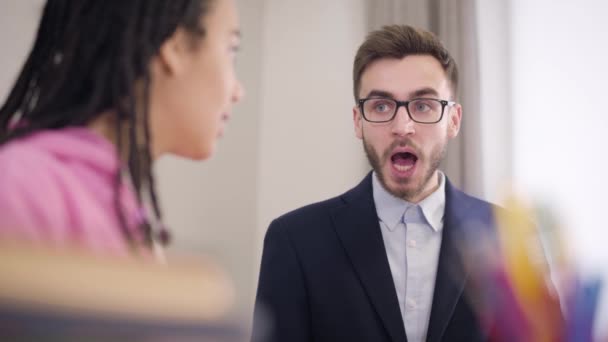 Retrato del entusiasta tutor masculino caucásico deletreando letras y borroso estudiante afroamericano repitiendo después de él. Jovencita aprendiendo lengua extranjera. Educación, inteligencia, tutoría . — Vídeos de Stock