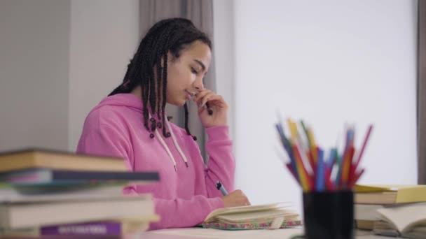 Jeune professeur caucasien venant à l'étudiant afro-américain et regardant à travers ses notes. Jolie fille timide regardant tuteur et enrouler les cheveux autour du doigt. Amour, sentiments, université . — Video